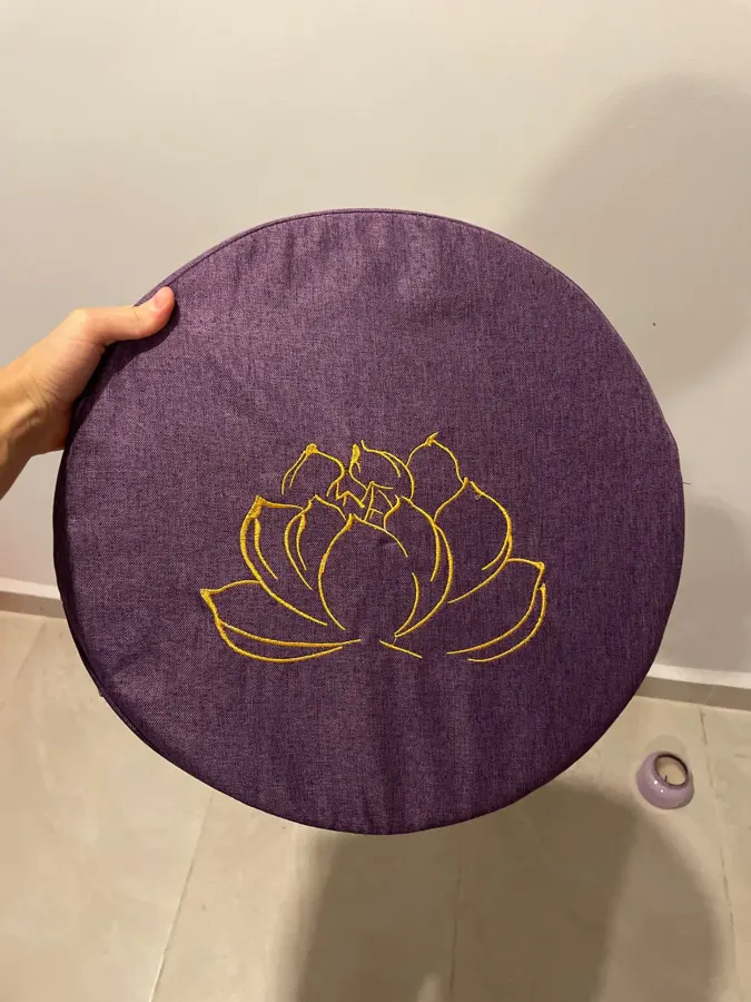 Verified buyer holding a purple meditation cushion to show the linen cover